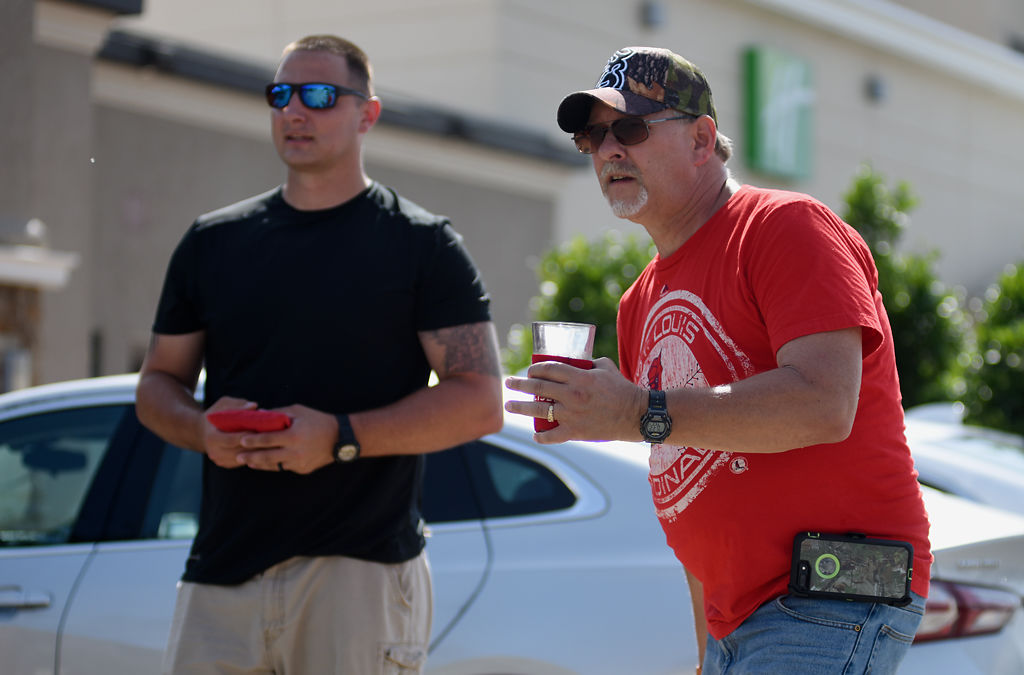 Brandon Baker, left, and Mike Johann play a game of cornhole against their kids